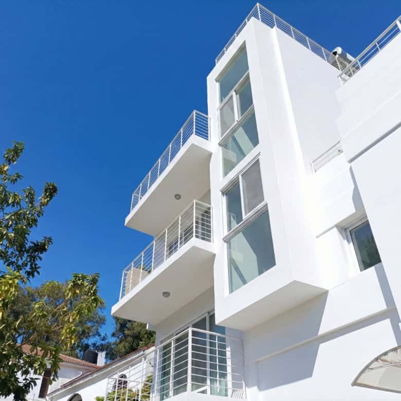 Contemporary white villa with multiple balconies in Sosua, Dominican Republic.