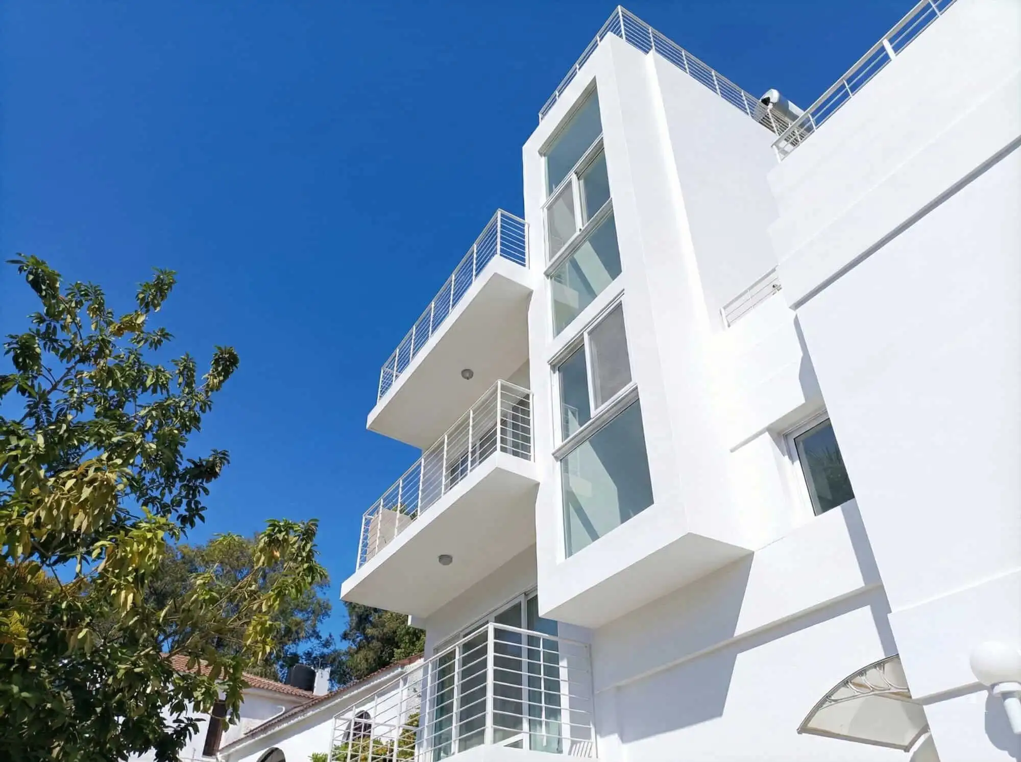 Contemporary white villa with multiple balconies in Sosua, Dominican Republic.