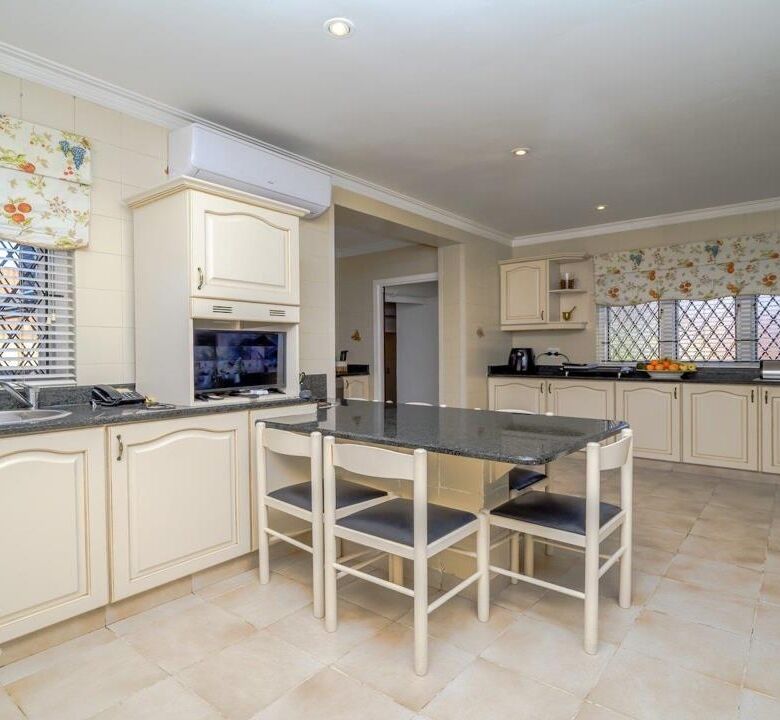 Elegant kitchen of a luxury 9-bedroom estate in Durban South, featuring spacious cabinetry and moder.