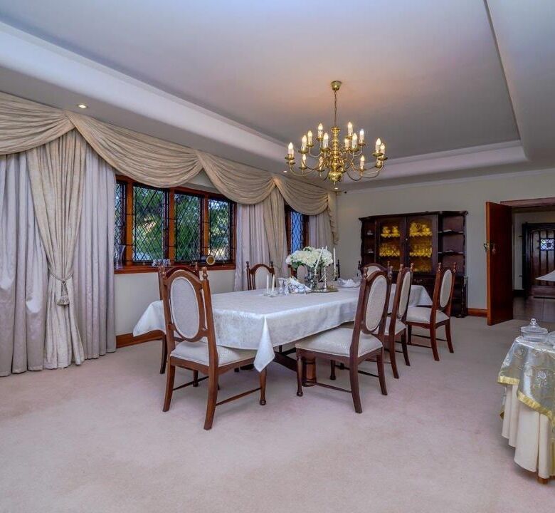 Elegant dining room in a luxury 9-bedroom estate in Durban South. Features classic decor, large wind.