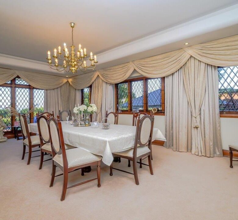 Elegant dining room with large windows and classic decor.
