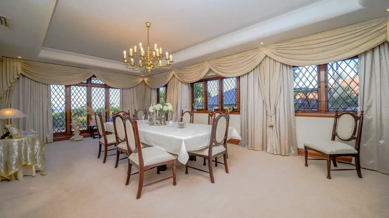 Elegant dining room with large windows and classic decor.