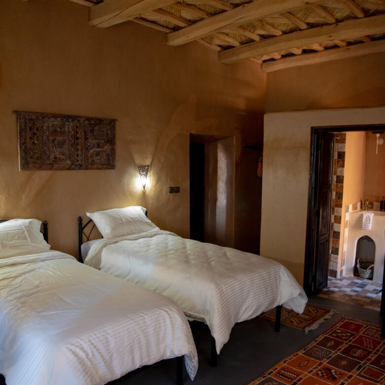 Hotel bedroom with two single beds and traditional decor.