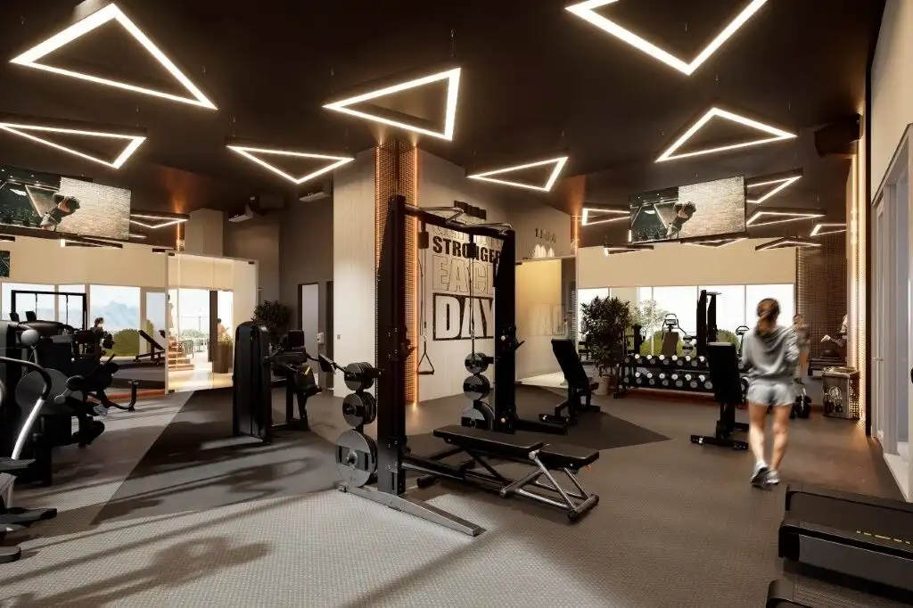 Modern gym in Tijuana luxury condos with stylish lighting and fitness equipment.