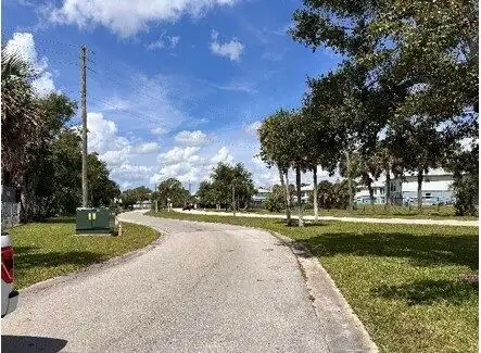 Plot of land for sale in Orlando, Florida with clear sky and trees.