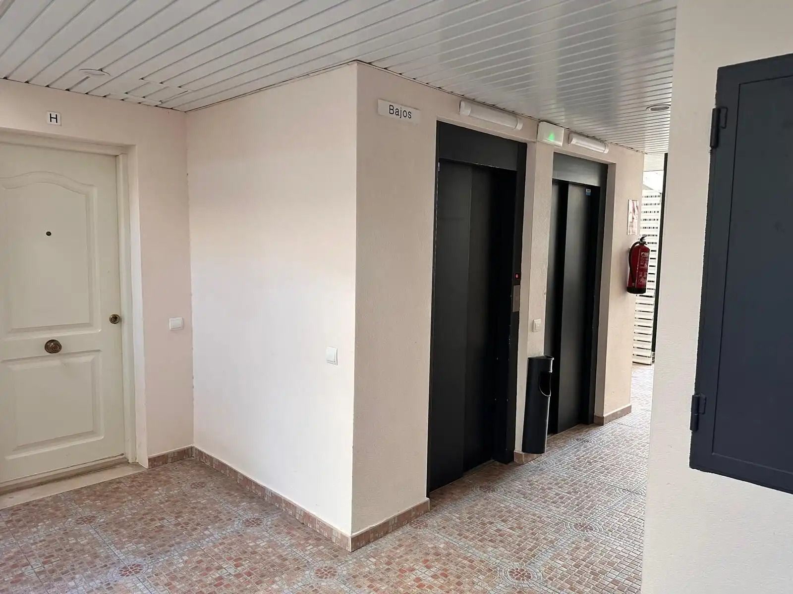 Elevator lobby with two elevators in a modern apartment complex.