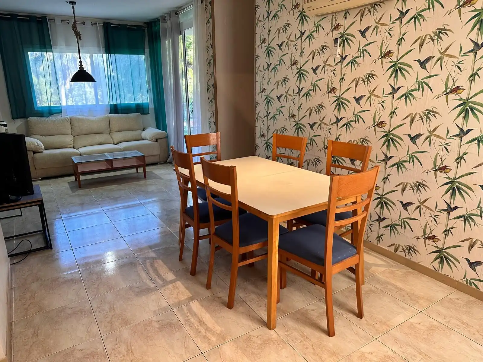 Spacious living and dining area in a 6/7 person tourist apartment with stylish decor and natural lig.