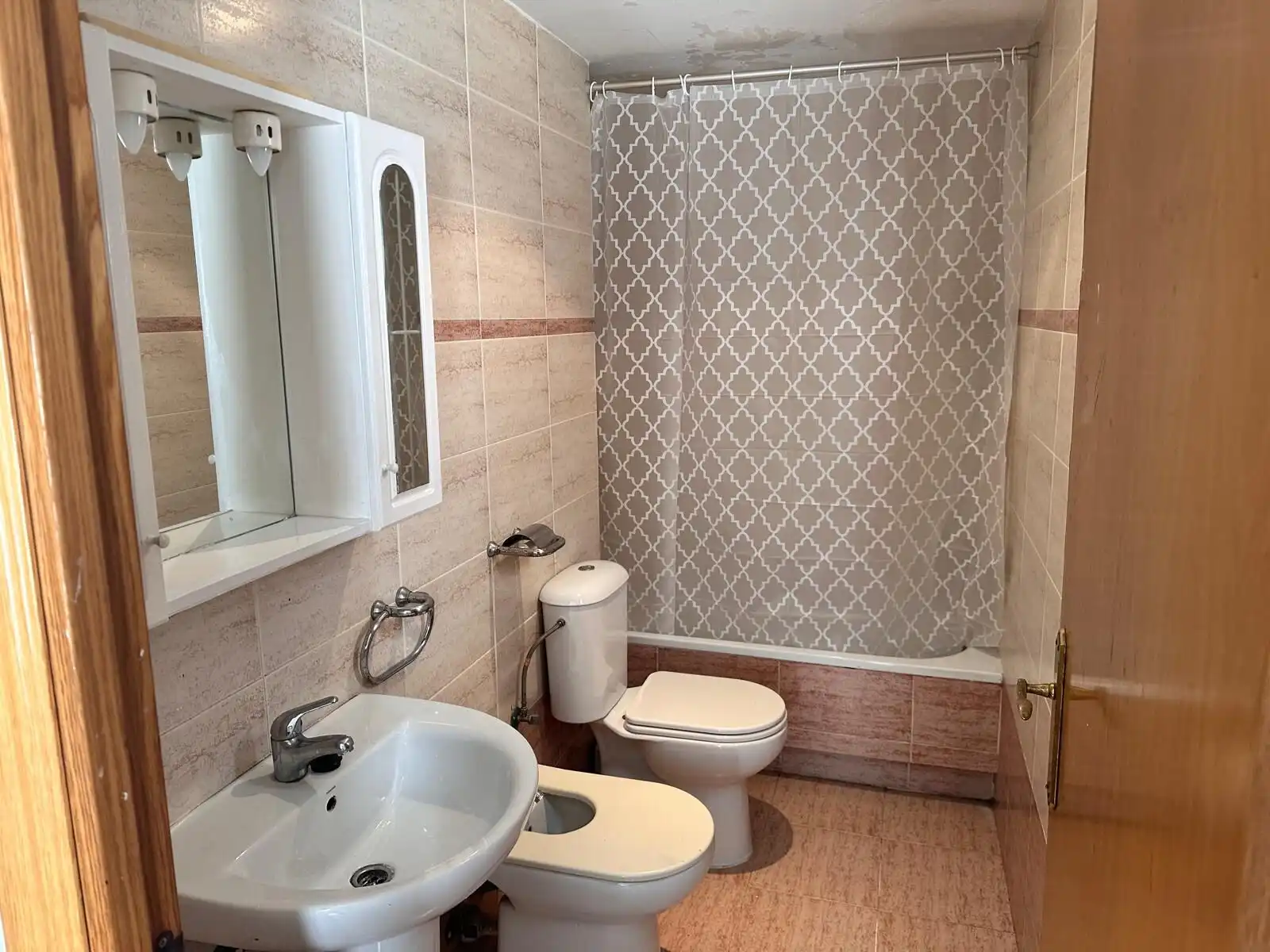 Bathroom with shower, toilet, and sink in a cozy tourist apartment.