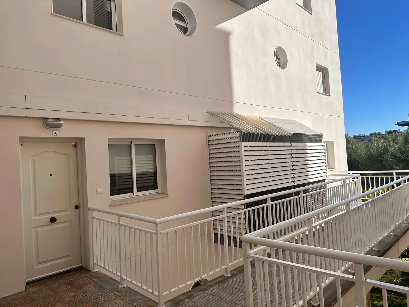 Bright apartment with balcony, white railing, and modern design features.