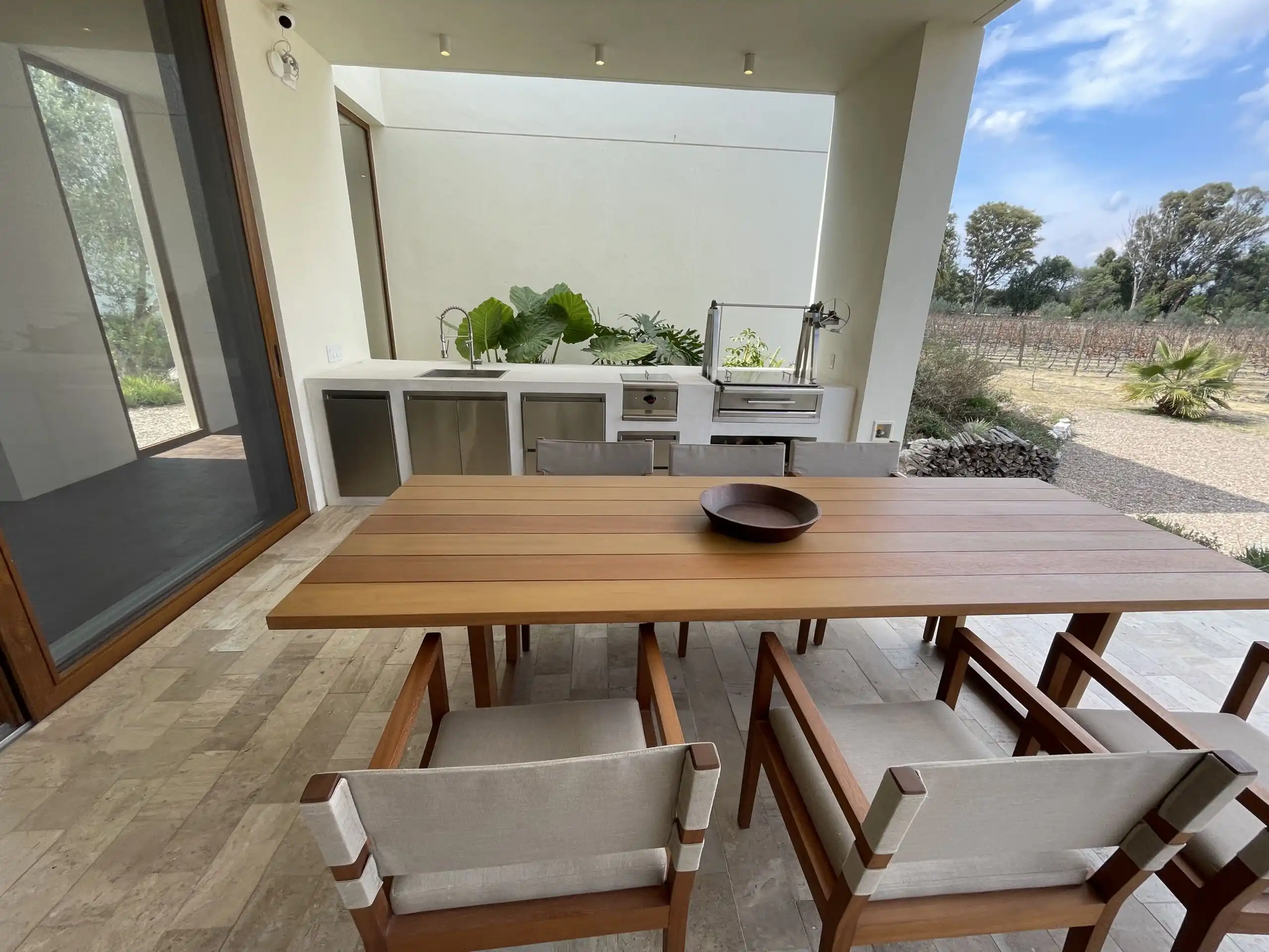 Modern outdoor dining area with vineyard views in San Miguel de Allende. Outdoor dining space overlooking scenic vineyard landscape in San Miguel de Allende.