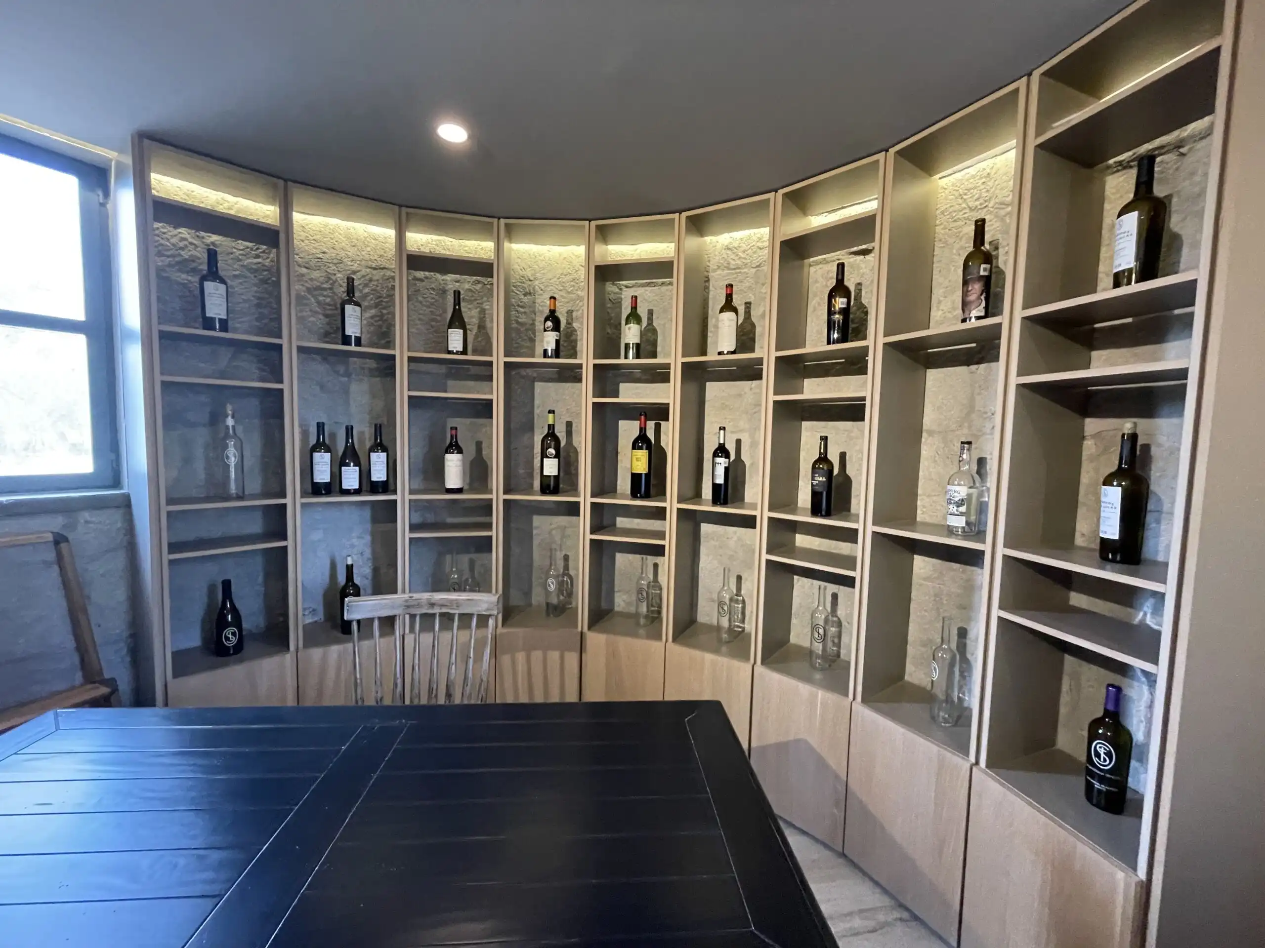Elegant wine storage with bottles showcased on curved shelves.