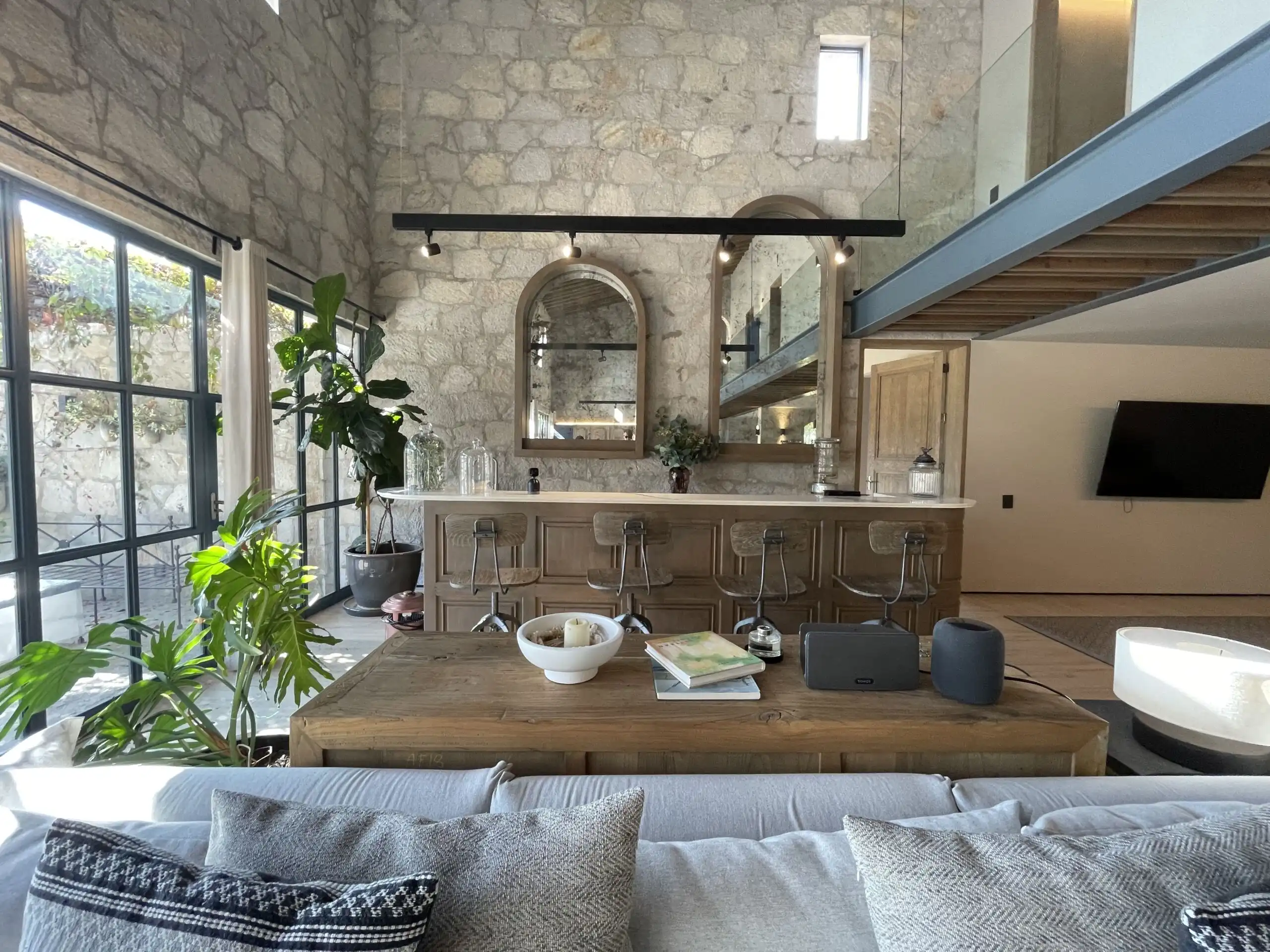 Elegant living space with stone walls and large windows in a luxury vineyard estate.