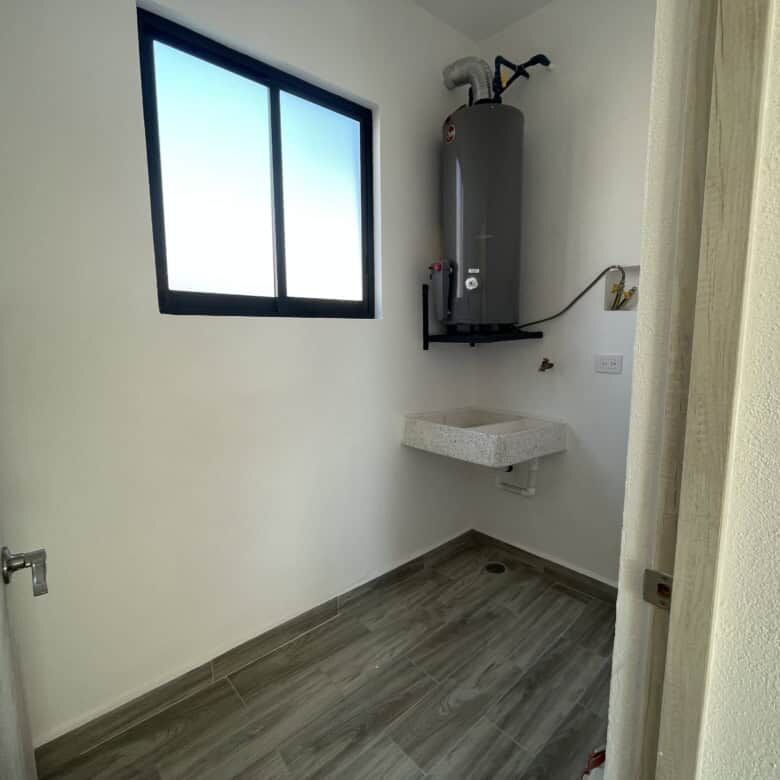 Laundry area with water heater and utility sink in a modern home.