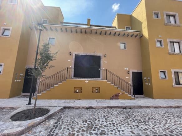 Bright yellow colonial-style house with stairs and black accents in Santo Domingo.