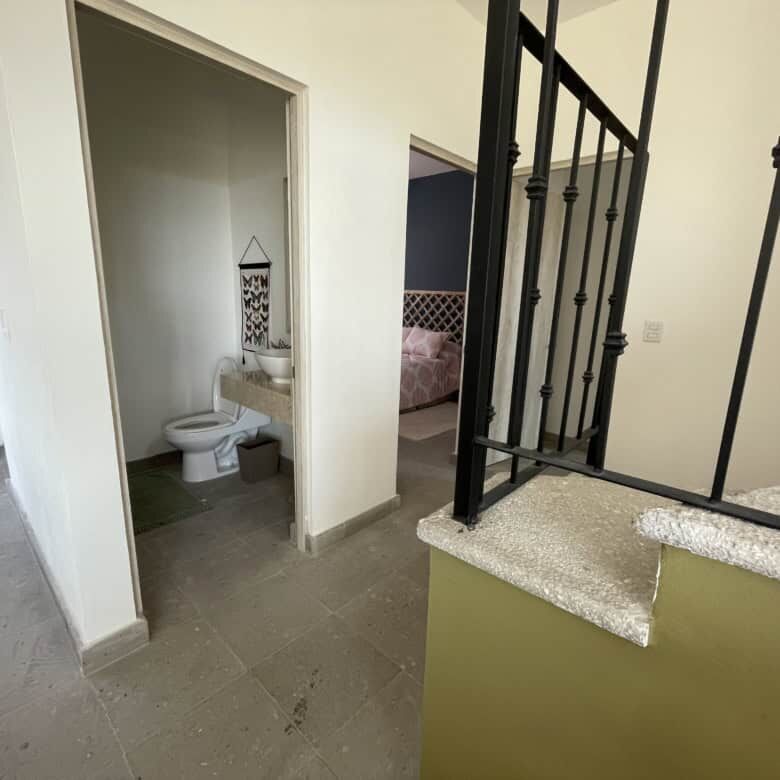 Modern interior staircase and bathroom in Santo Domingo home.