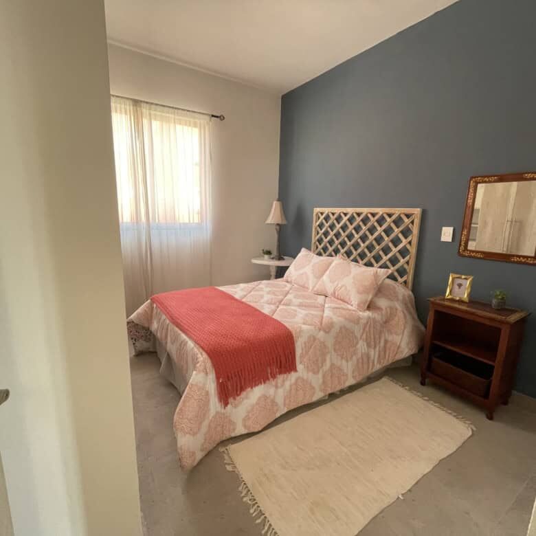 Bright bedroom with a comfortable bed and stylish decor in Santo Domingo. Perfect for relaxing in a.