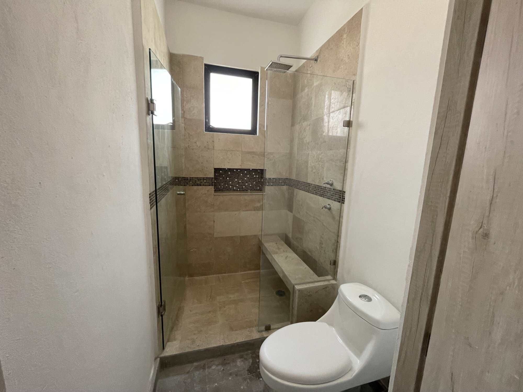 Modern Bathroom in Santo Domingo Home Tour Modern bathroom with walk-in shower, bench, and small window in Santo Domingo home.