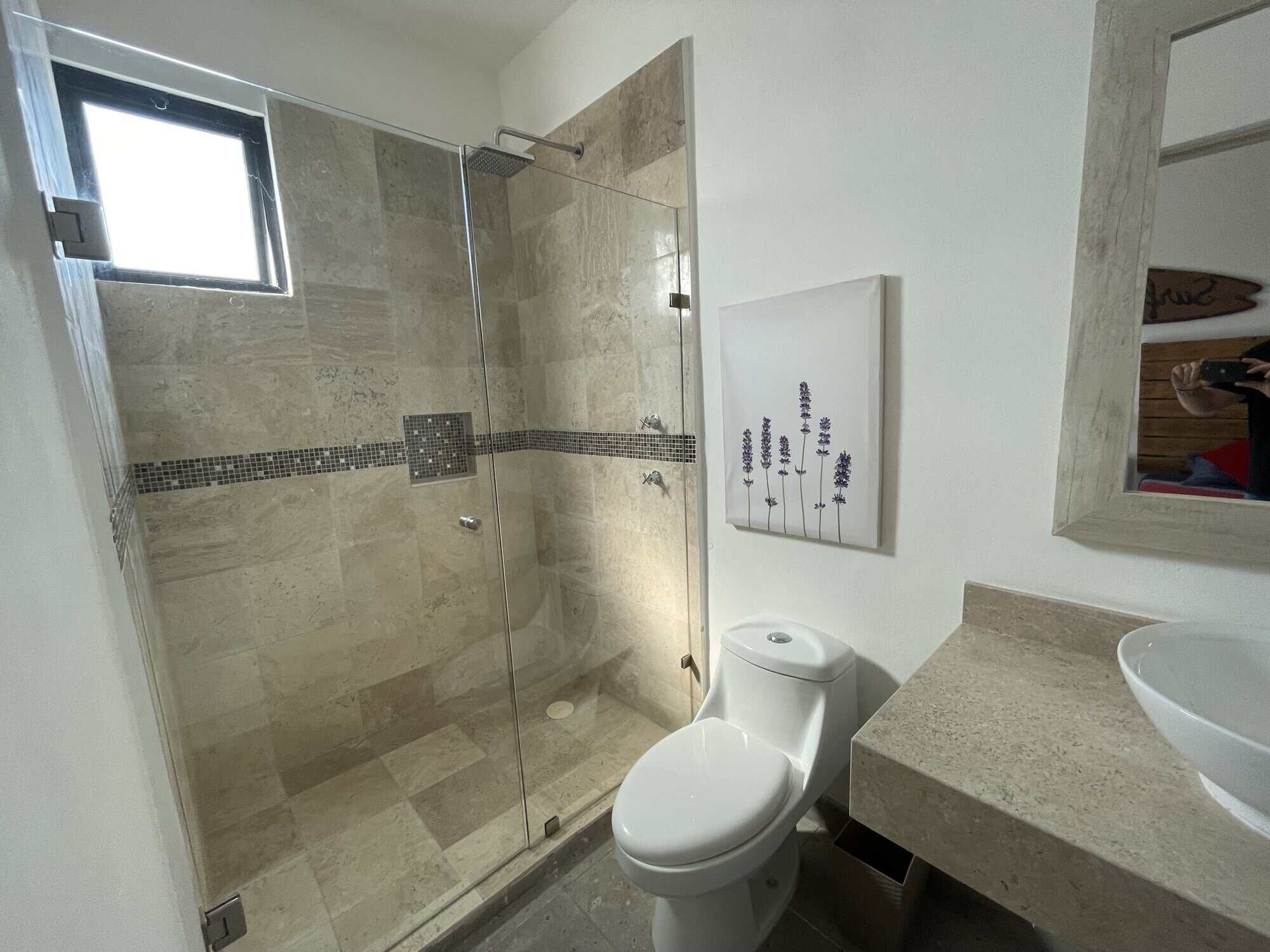 Modern bathroom with walk-in shower in Santo Domingo home tour Bathroom with walk-in shower, toilet, and modern sink in Santo Domingo home tour.