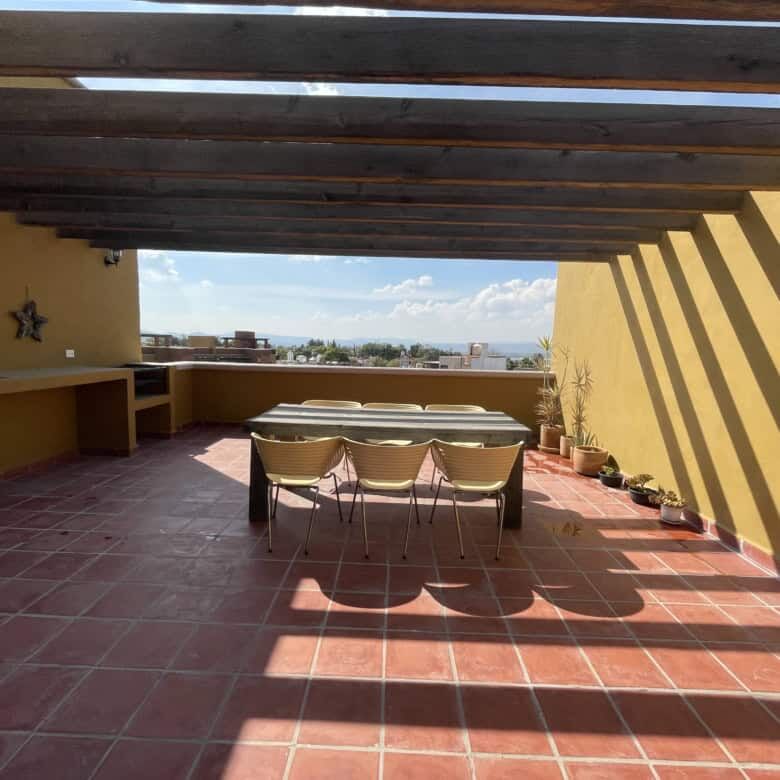 Spacious rooftop terrace with seating area and scenic city views in Santo Domingo home.