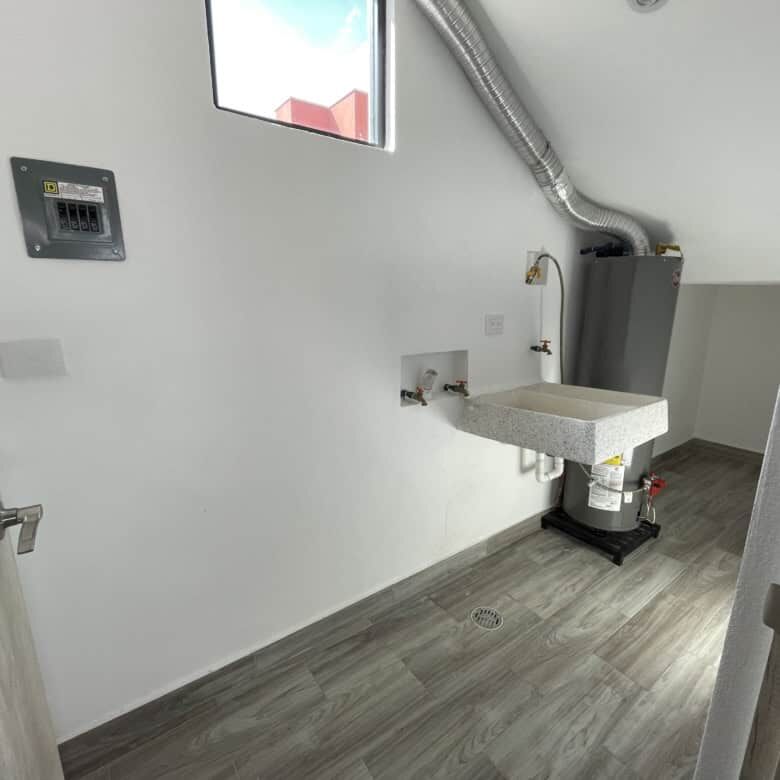Laundry room with utility sink and modern finishes in a stylish home.