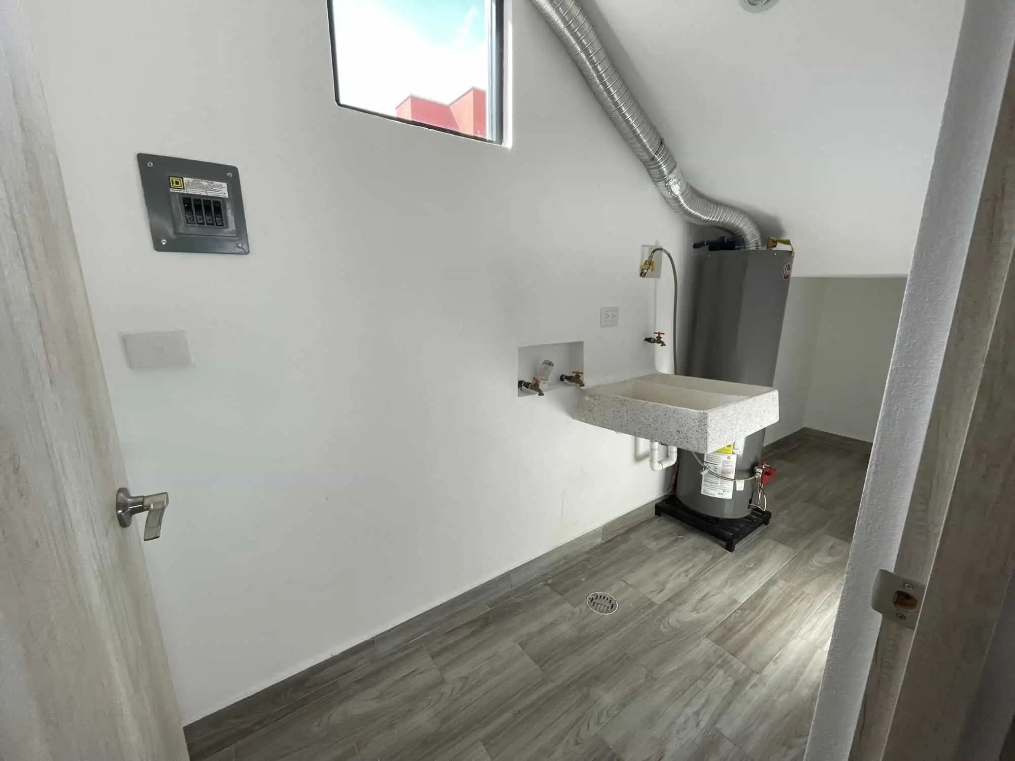 Laundry room with utility sink and modern finishes in a stylish home.