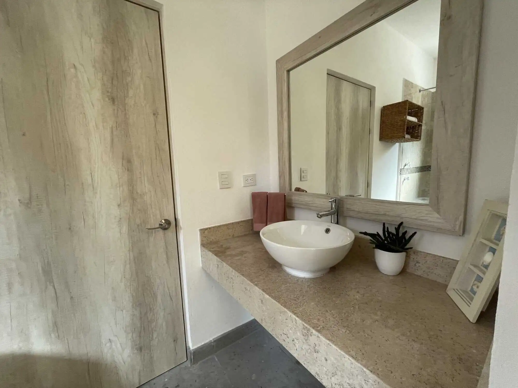 Bathroom with a round vessel sink and large mirror in a modern colonial-style home.