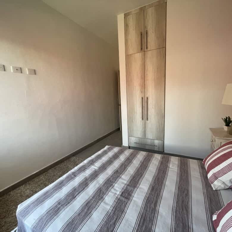 Modern colonial bedroom with a large bed, wooden wardrobe, and cozy decor in La Serena, San Miguel d.