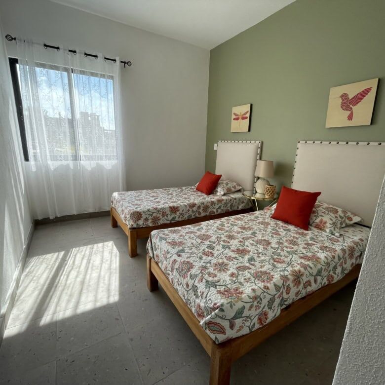 Interior view of a 3-bedroom home in La Serena Residencial, featuring two beds, decorative pillows,.