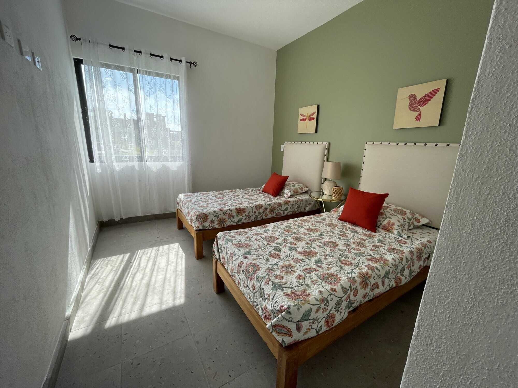 Interior view of a 3-bedroom home in La Serena Residencial, featuring two beds, decorative pillows,.