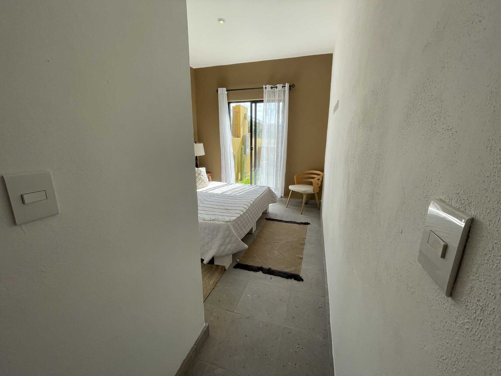Bright bedroom with large window, cozy decor, and minimalist design.