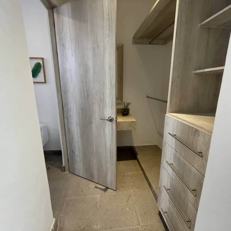In closet with built-in shelves and drawers.