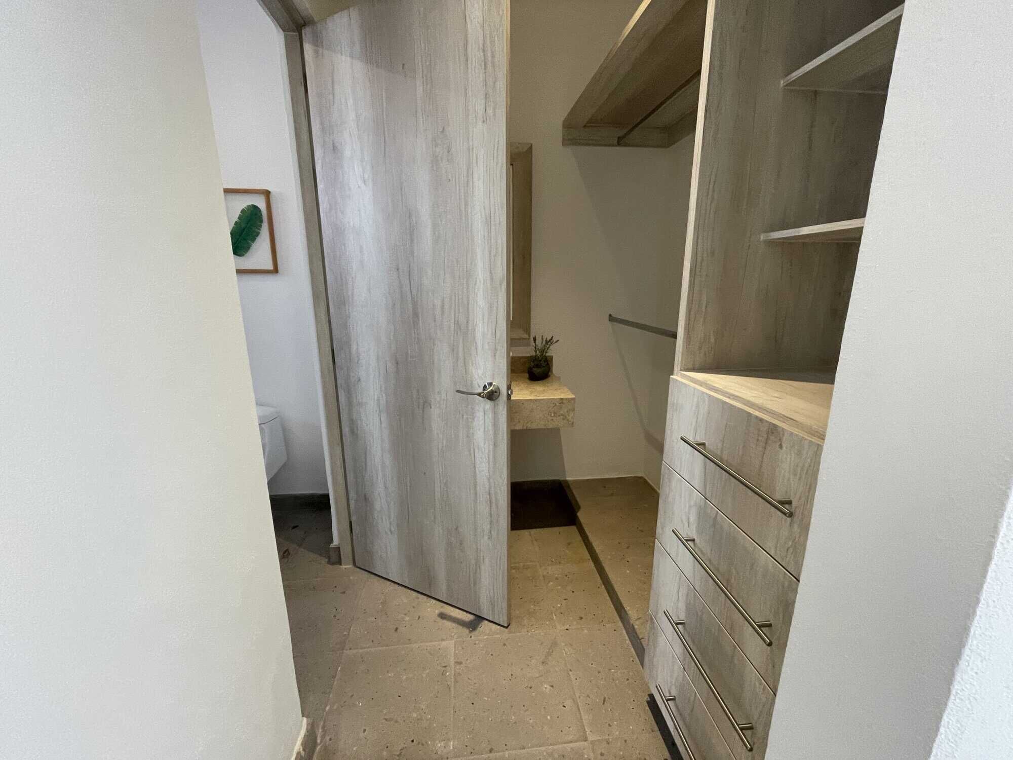 In closet with built-in shelves and drawers.