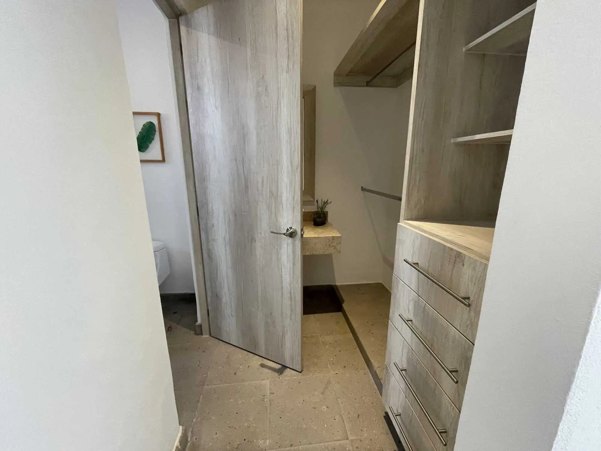 In closet with built-in shelves and drawers.