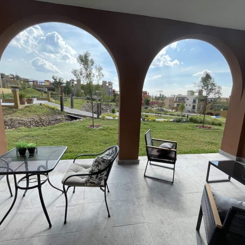 Outdoor patio of a 3-bedroom home in La Serena Residencial, featuring stylish furniture and lush gre.
