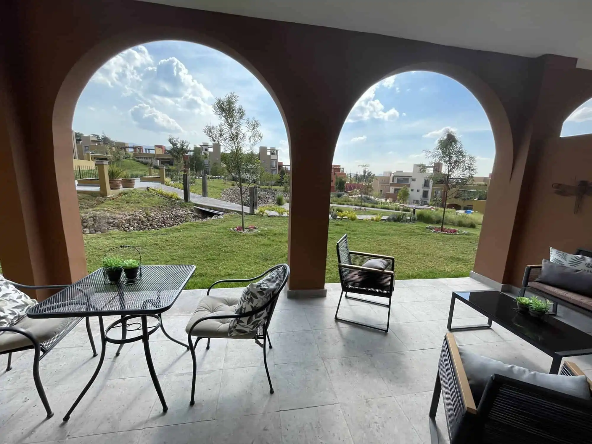 Outdoor patio of a 3-bedroom home in La Serena Residencial, featuring stylish furniture and lush gre.