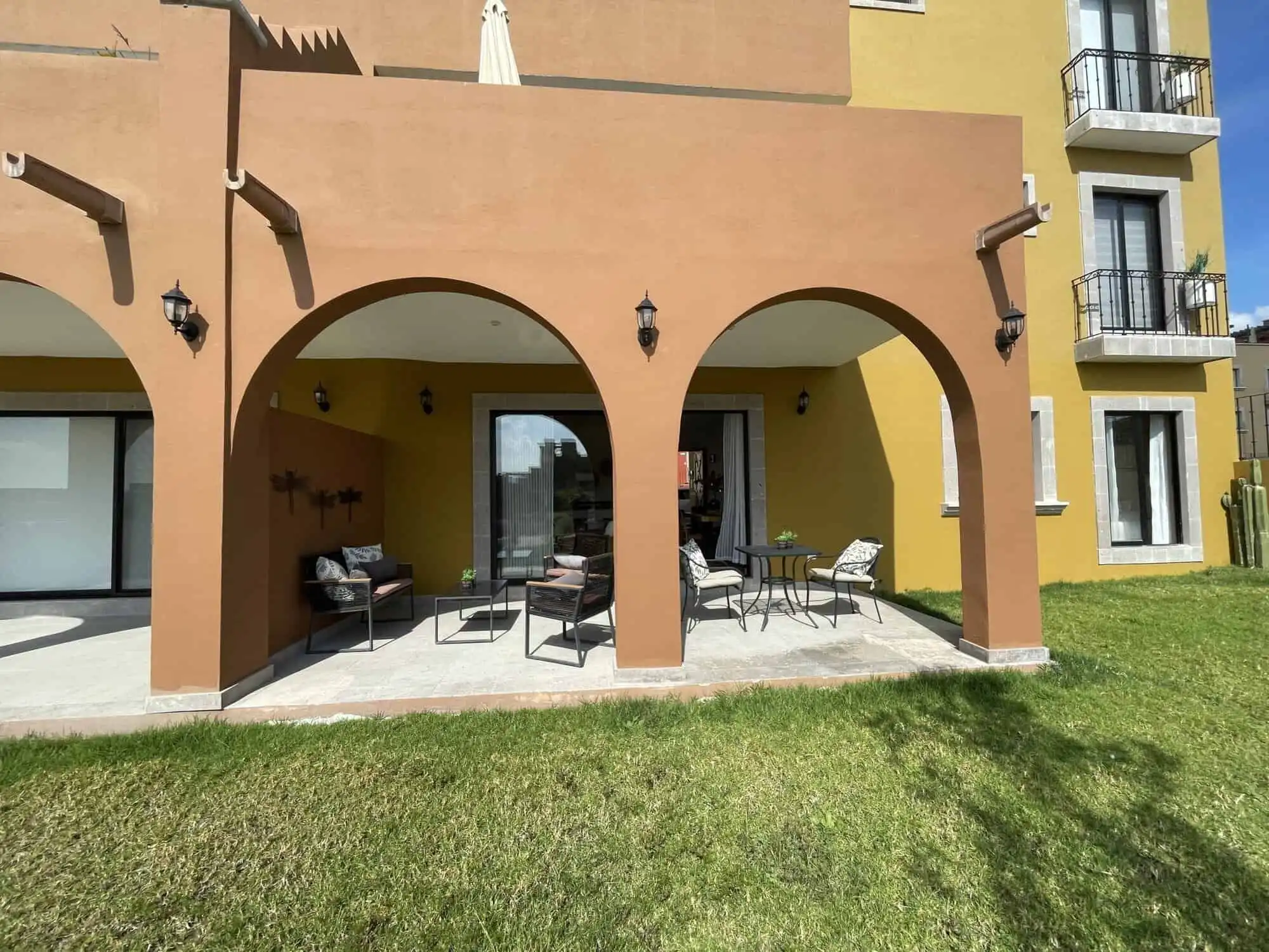 Outdoor patio with comfortable seating under arches at La Serena Residencial, San Miguel de Allende.