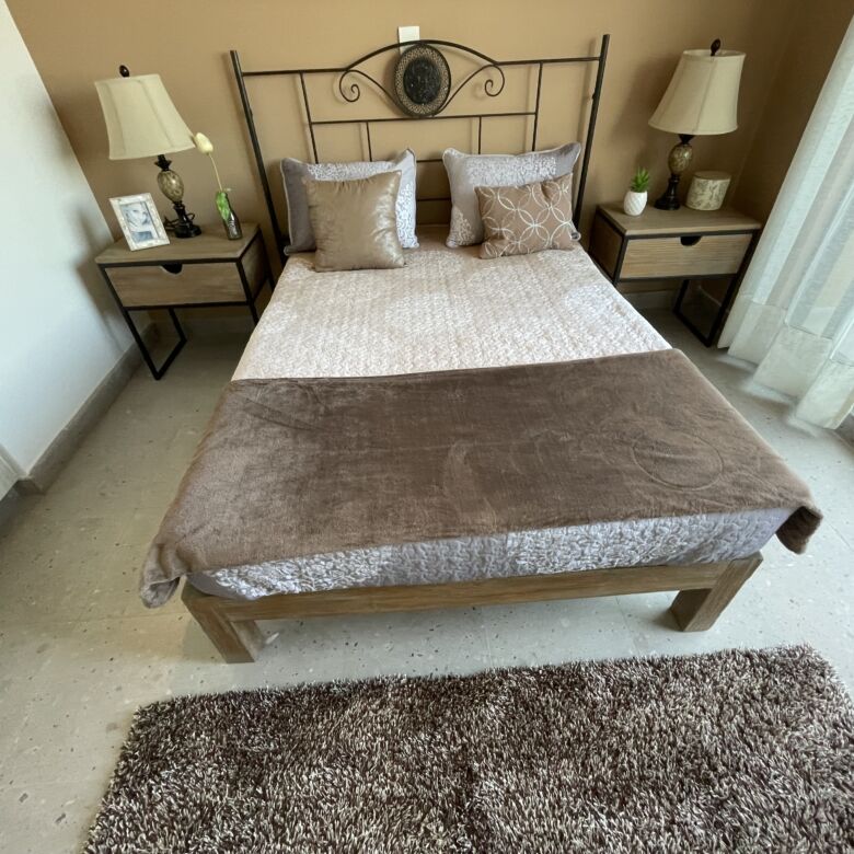 Cozy bedroom with modern decor, two nightstands, and large window in San Miguel de Allende.