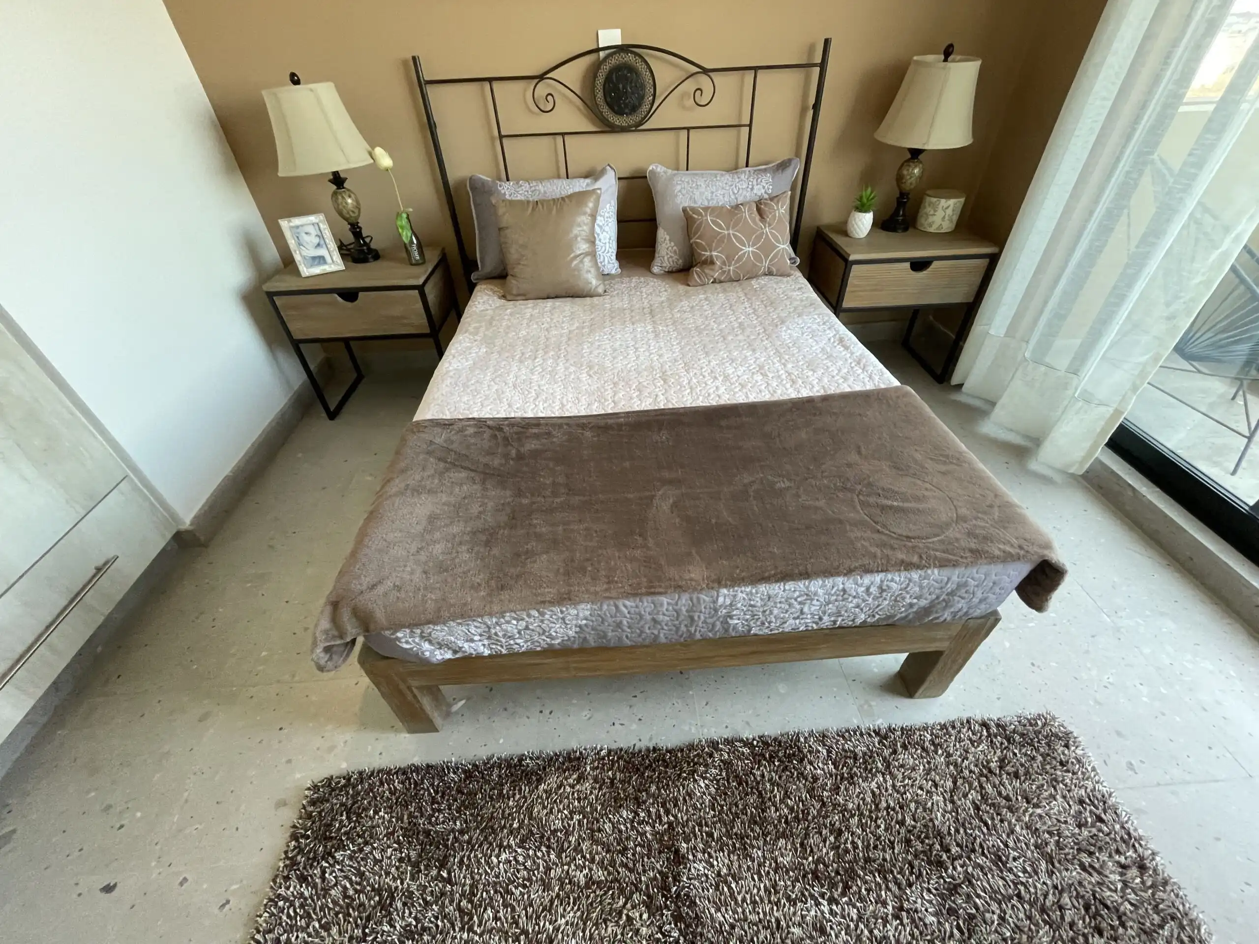Cozy bedroom with modern decor, two nightstands, and large window in San Miguel de Allende.
