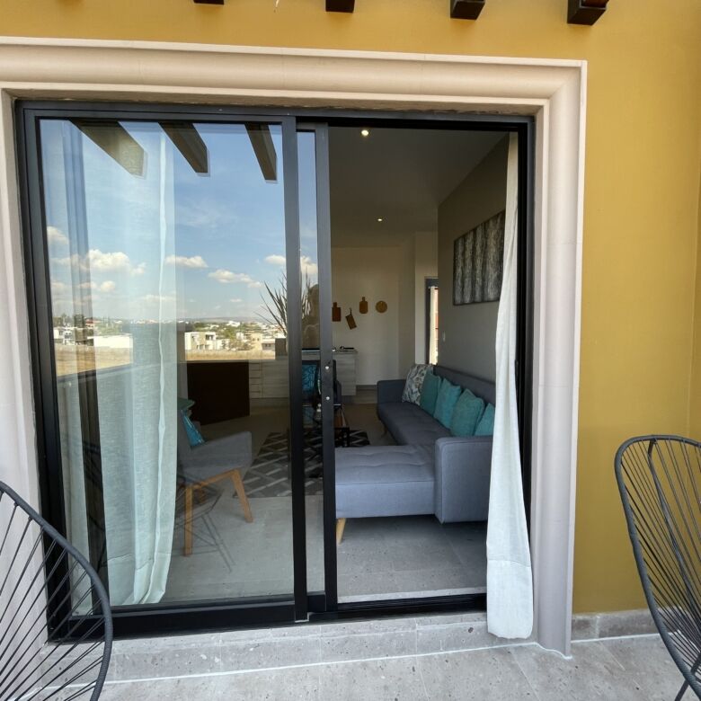 Bright view of the living room through sliding glass doors in a modern apartment.