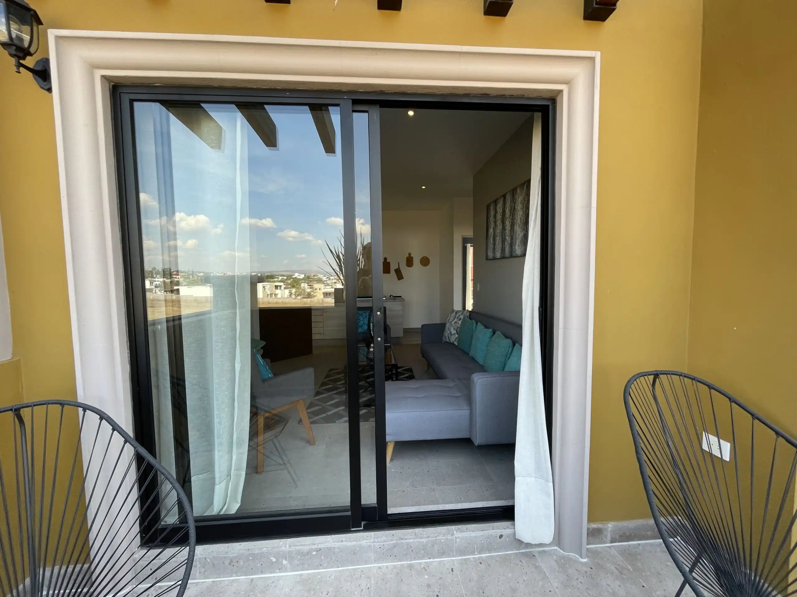 Bright view of the living room through sliding glass doors in a modern apartment.