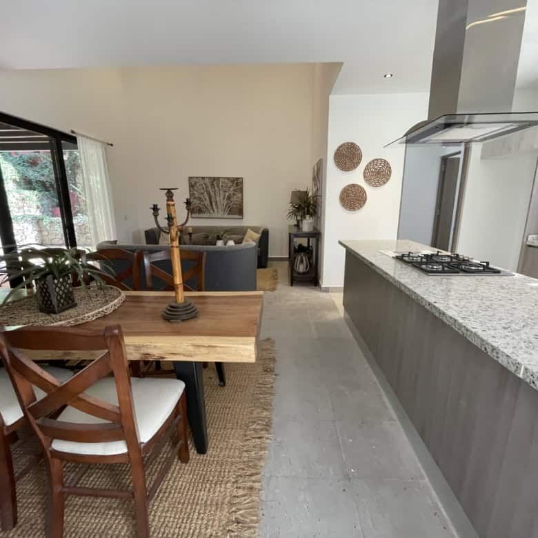 Spacious kitchen with granite countertops, stylish dining table, and natural light.