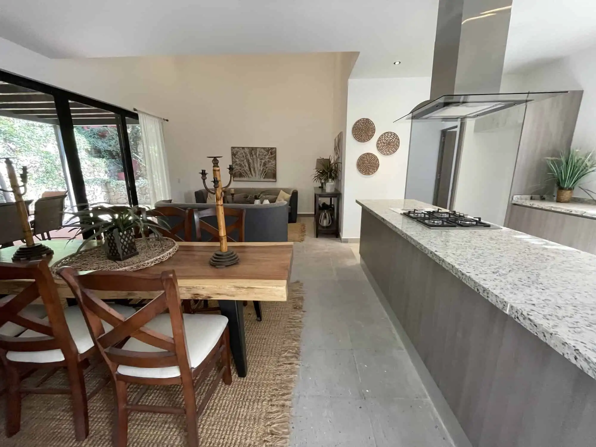Spacious kitchen with granite countertops, stylish dining table, and natural light.