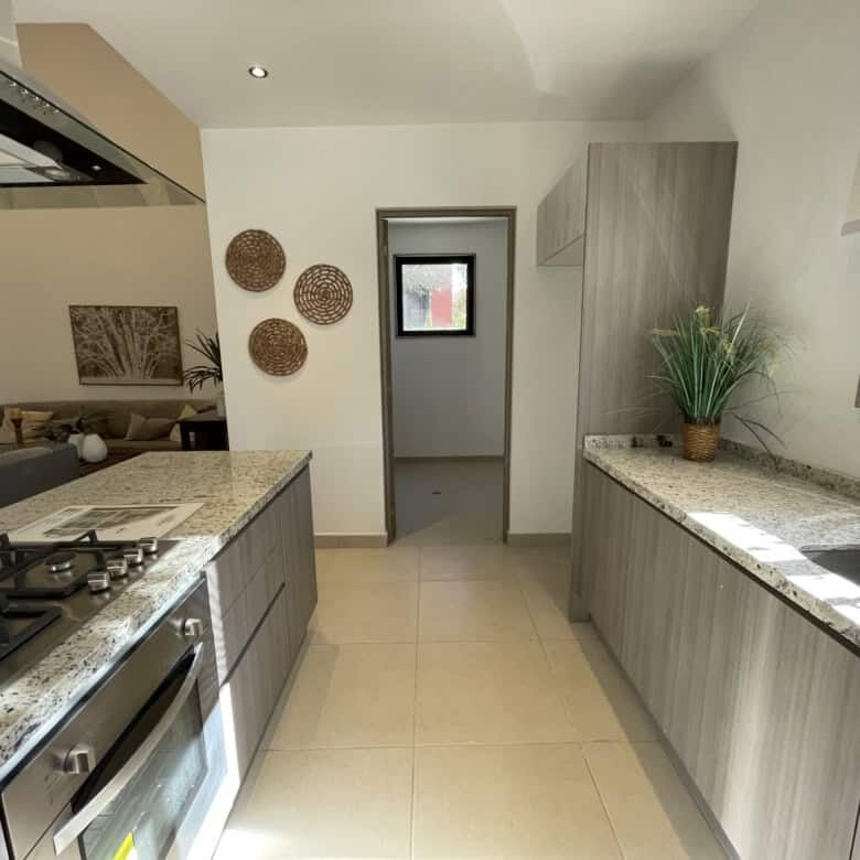 Bright kitchen featuring granite surfaces, a window view, and contemporary cabinetry in San Miguel d.