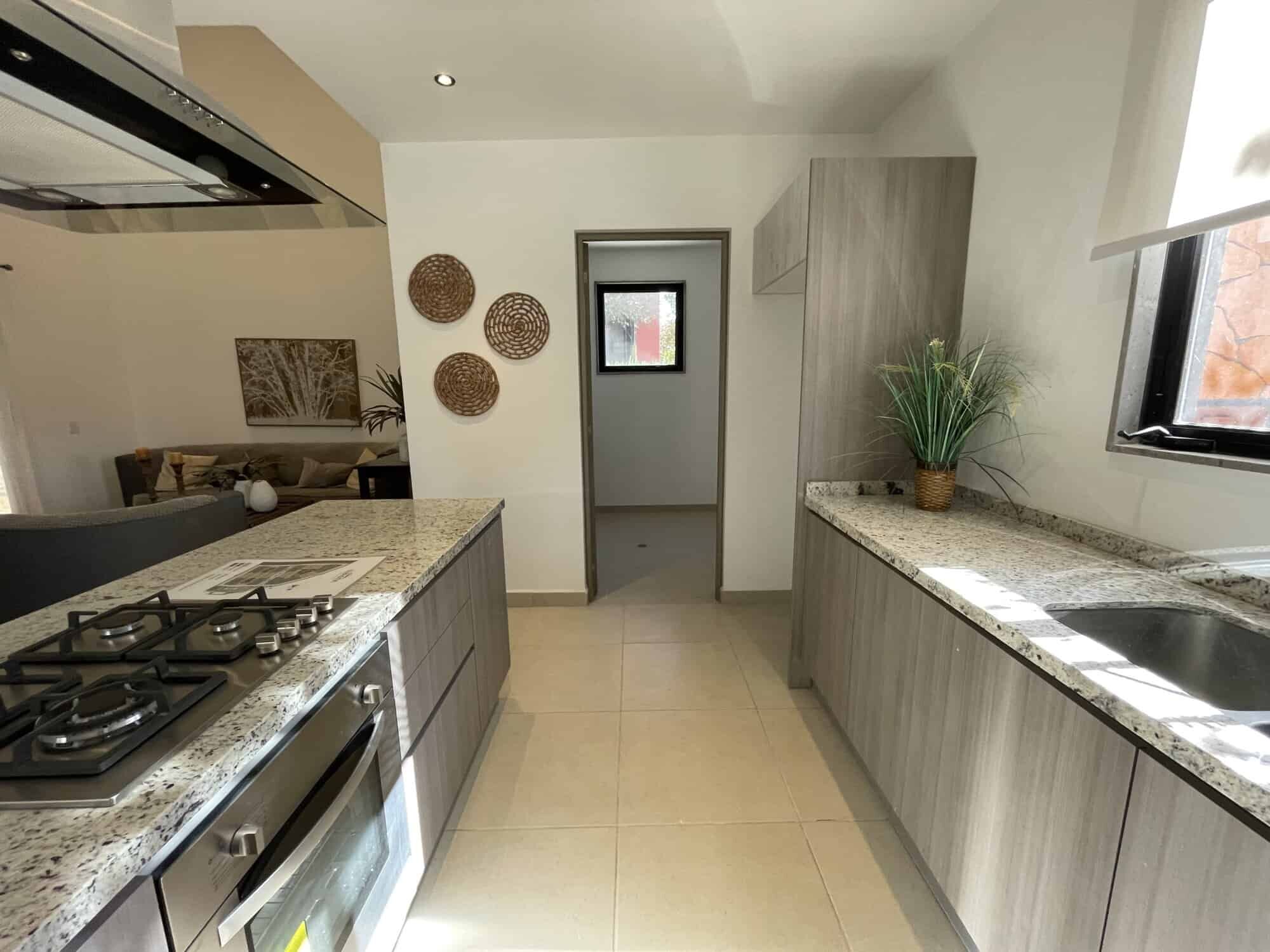 Bright kitchen featuring granite surfaces, a window view, and contemporary cabinetry in San Miguel d.