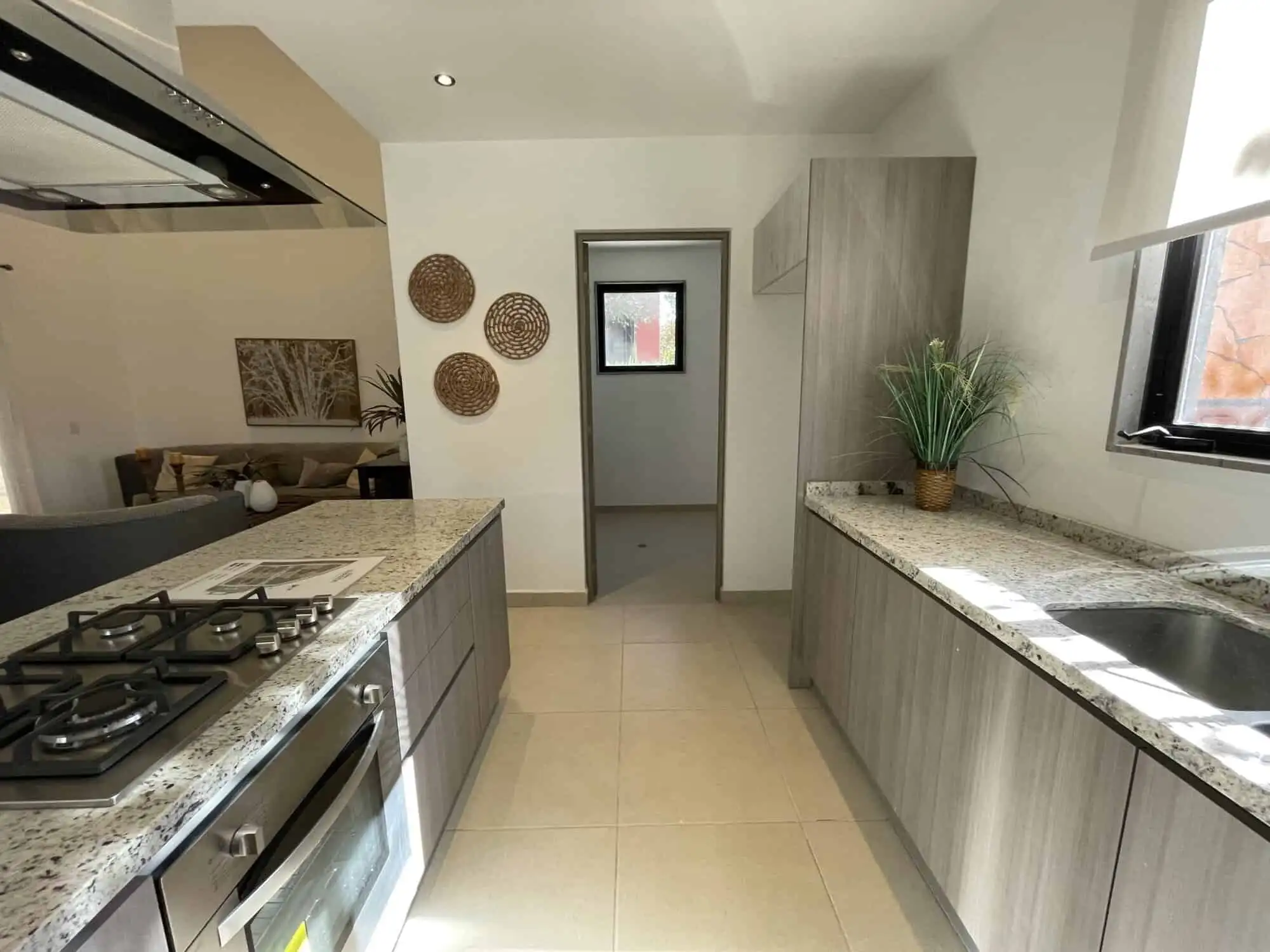 Bright kitchen featuring granite surfaces, a window view, and contemporary cabinetry in San Miguel d.