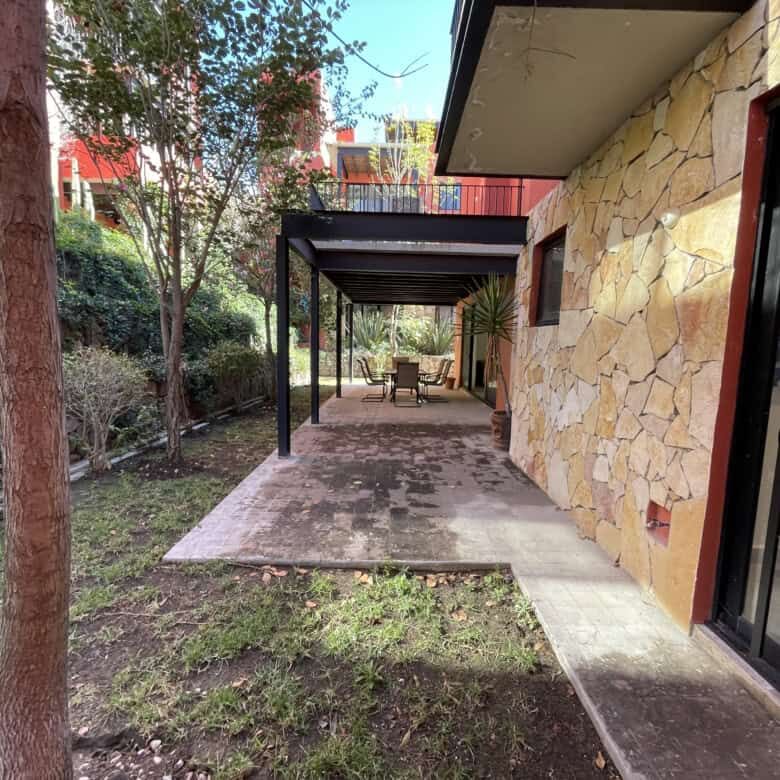 Beautiful outdoor patio with stone wall and shaded seating area in Punta de Cielo.