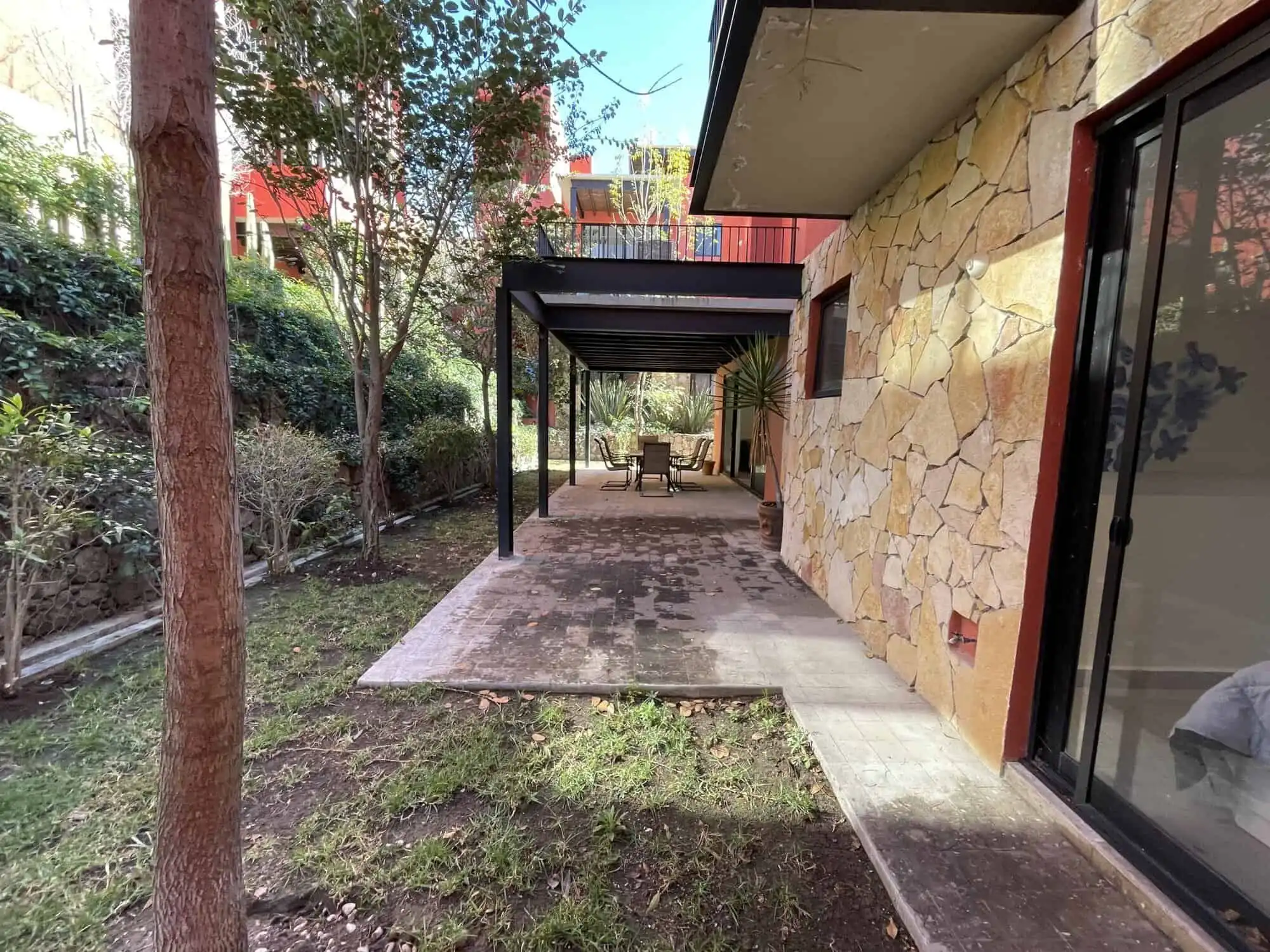 Beautiful outdoor patio with stone wall and shaded seating area in Punta de Cielo.