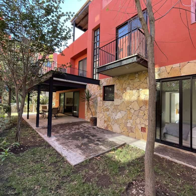 Spacious exterior view of a luxury 4-bedroom house with a terrace and lush garden in San Miguel de A.