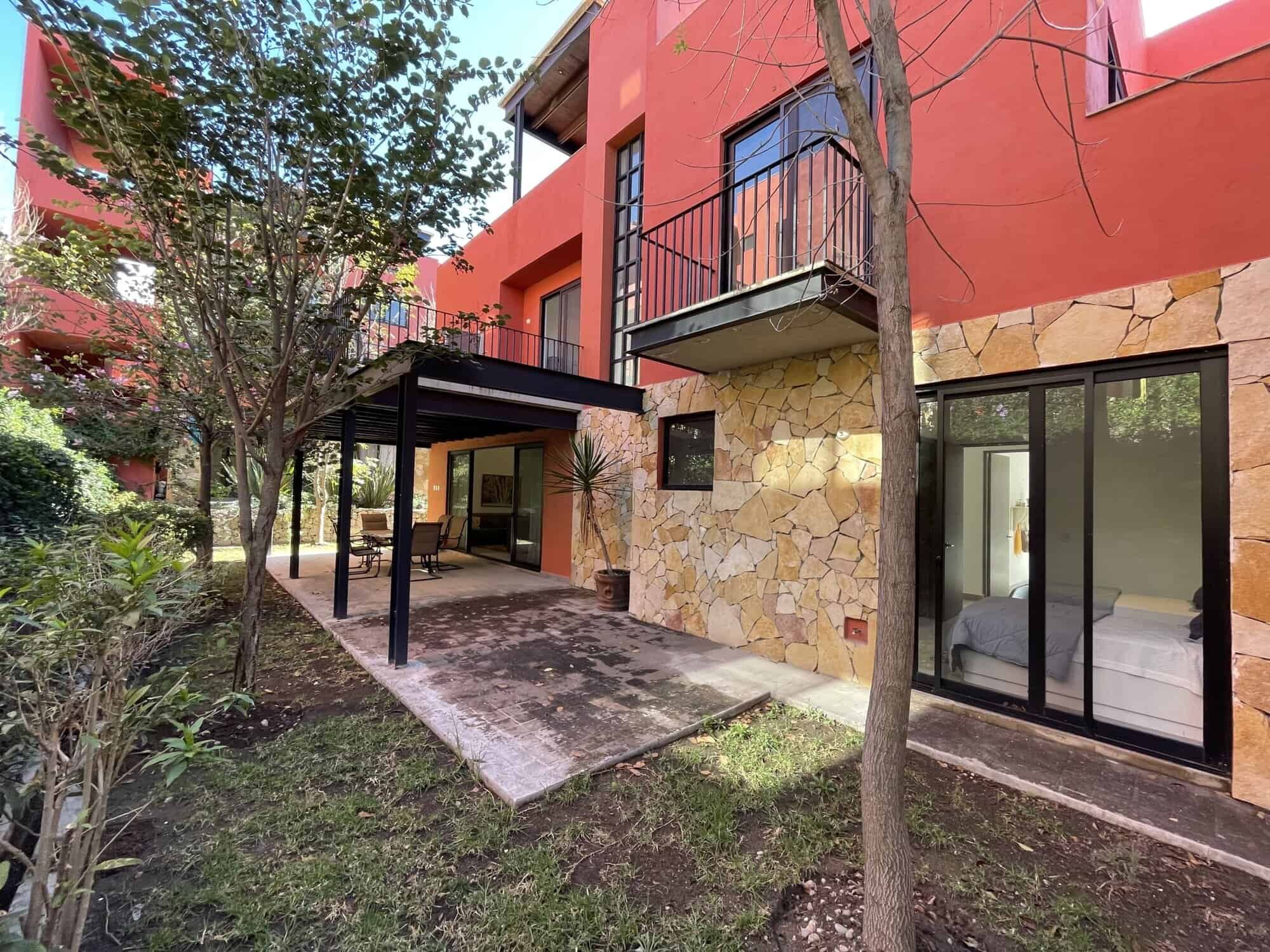 Spacious exterior view of a luxury 4-bedroom house with a terrace and lush garden in San Miguel de A.