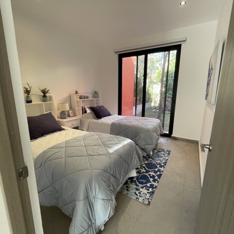 Spacious bedroom with modern decor and natural light, perfect for comfortable living in a luxury pro.